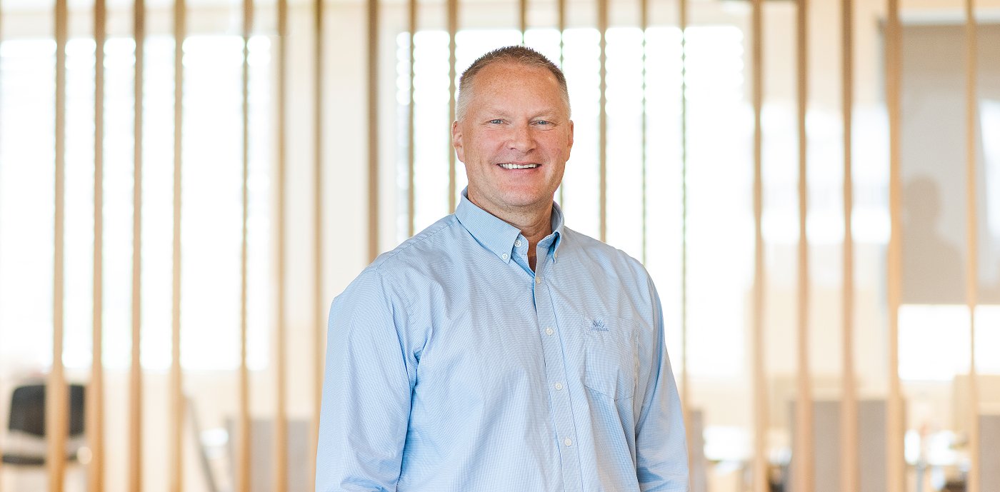 Portrætbillede af Ronny Lindås, koncerndirektør for IT og digitalisering i GK, taget indendørs foran en lamelvæg. Portrætbillede af Ronny Lindås, koncerndirektør for IT og digitalisering i GK, taget indendørs foran en lamelvæg.