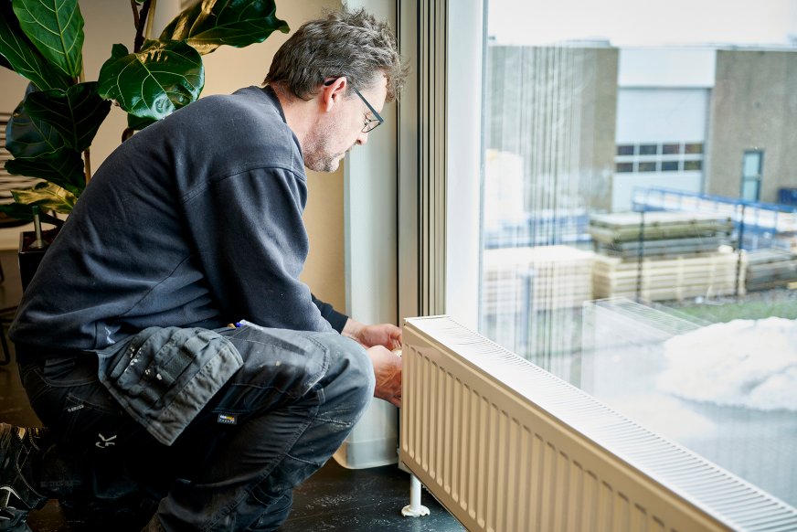 Billede af en medarbejder, der yder service på en radiator 