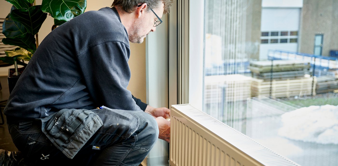 Billede af en medarbejder, der yder service på en radiator 