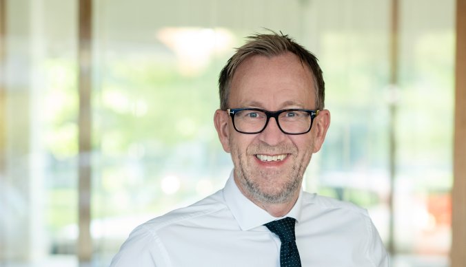 Bilde av konsernsjef i GK Kim Robert Lisø stående i et åpent kontorlandskap
