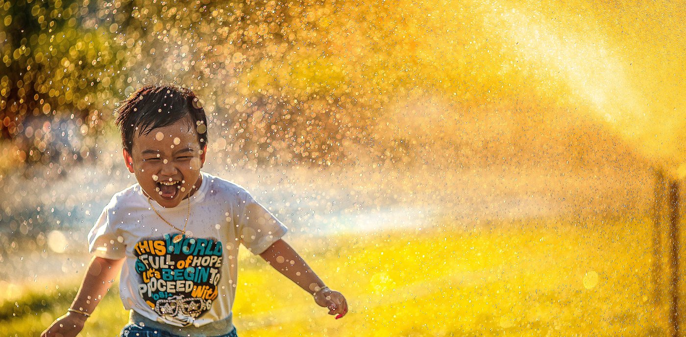Barn som løper gjennom spreder på en sommerdag