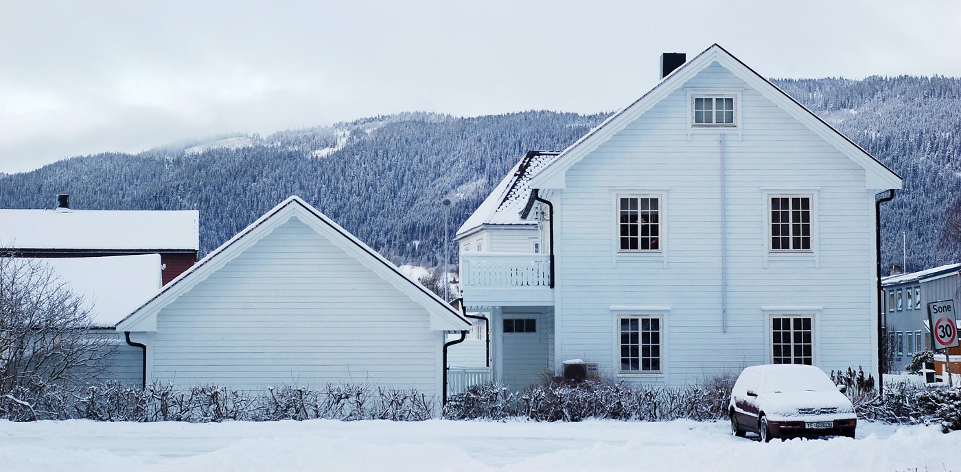 Frosne vannrør Hvit enebolig på vinteren med snø på taket