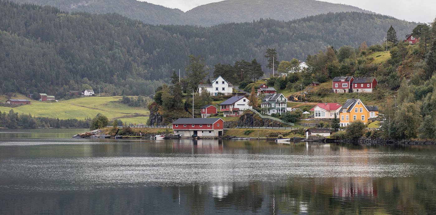 Lekkasjestopper - god og billig forsikring Bygd sett fra andre siden av en innsjø