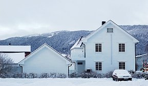 Frosne vannrør Hvit enebolig på vinteren med snø på taket